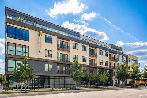 A modern multi-story building with balconies and large windows.