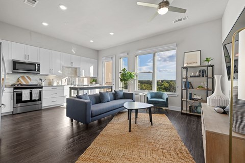 A modern kitchen with a blue couch and a ceiling fan.