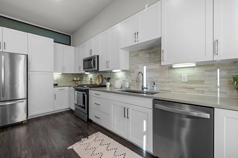A modern kitchen with white cabinets and stainless steel appliances.