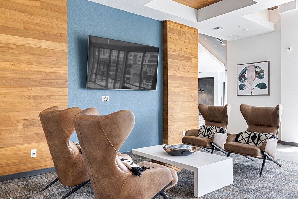 a living room with chairs and a table and a television