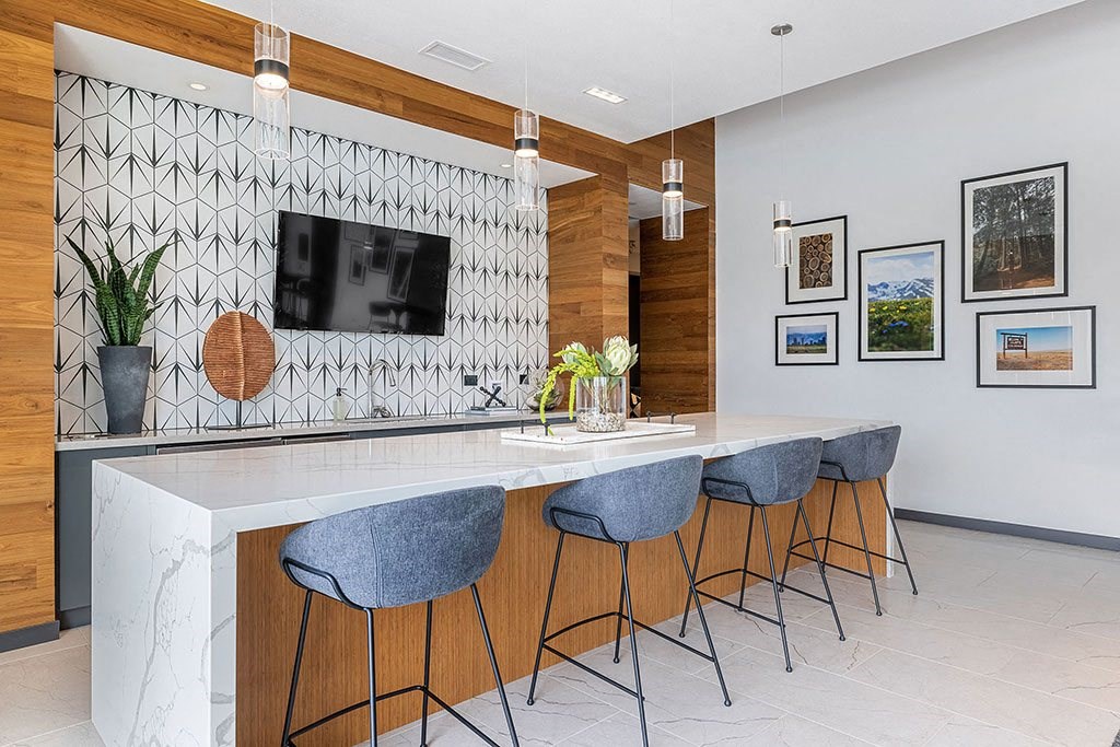 a kitchen with a marble counter top and chairs