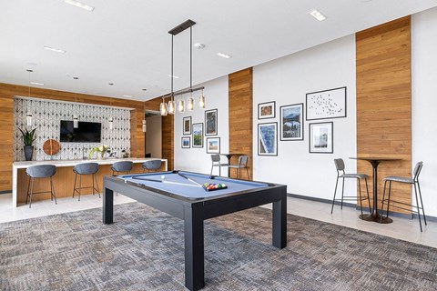 a game room with a pool table and a bar