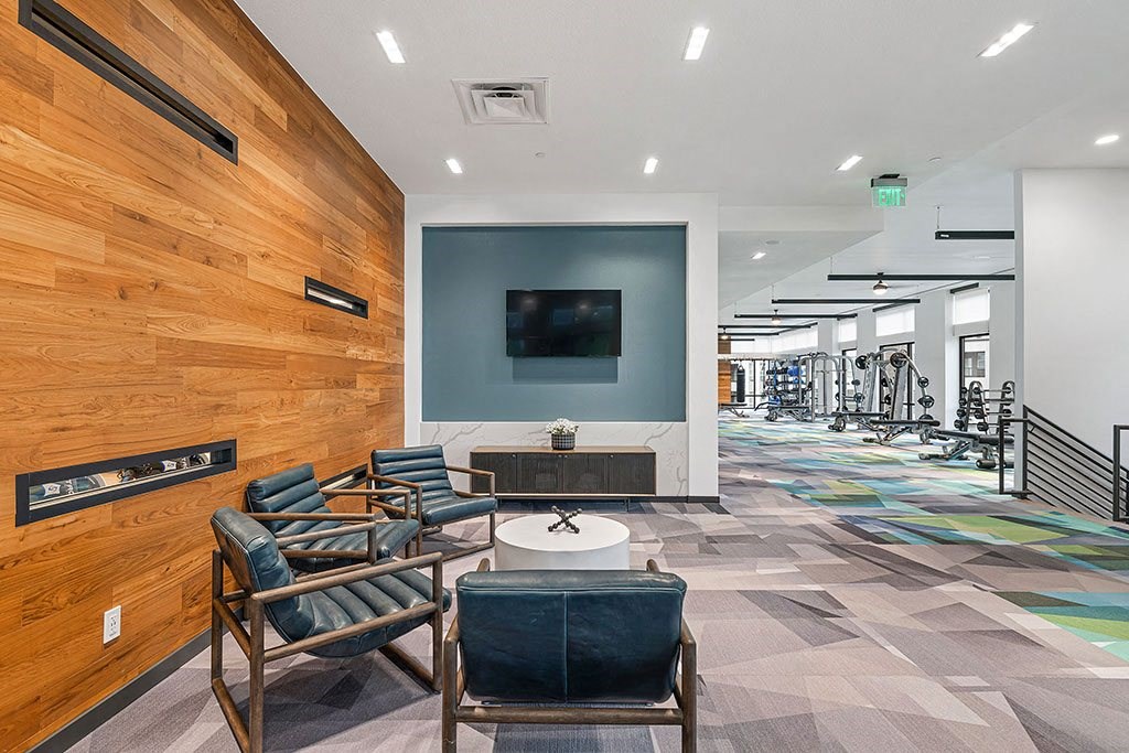the lobby of a gym with chairs and a television