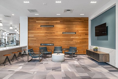 a lobby with chairs and a table and a television
