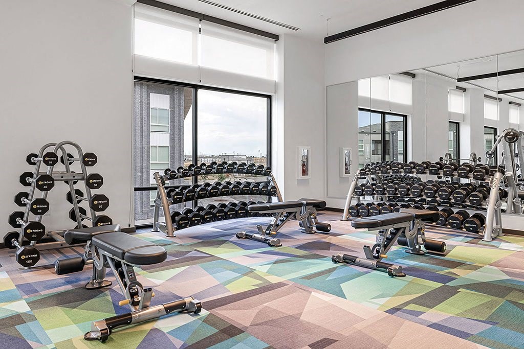 a workout room with weights and cardio equipment in a building