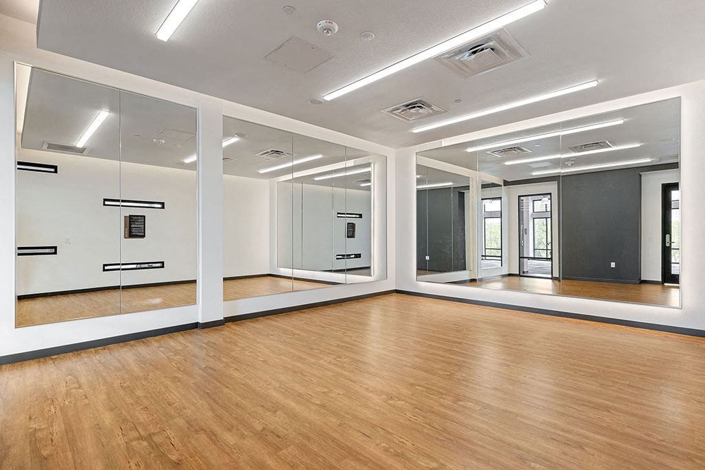 an empty room with mirrored walls and a wood floor