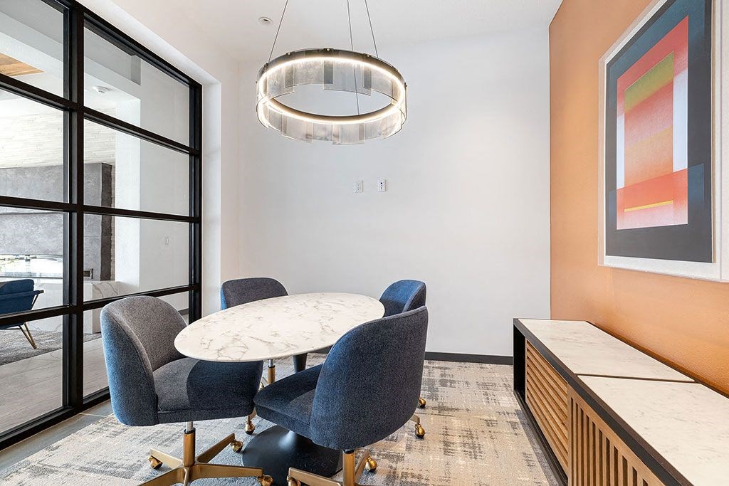 a dining room with a table and chairs and a large window