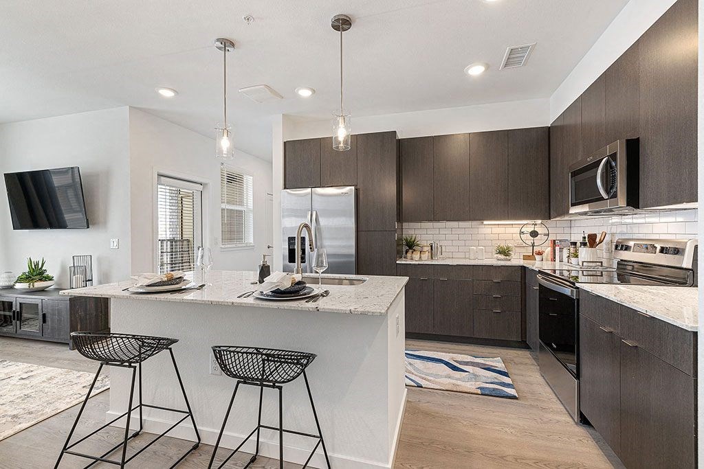 a kitchen with a large island with two bar stools