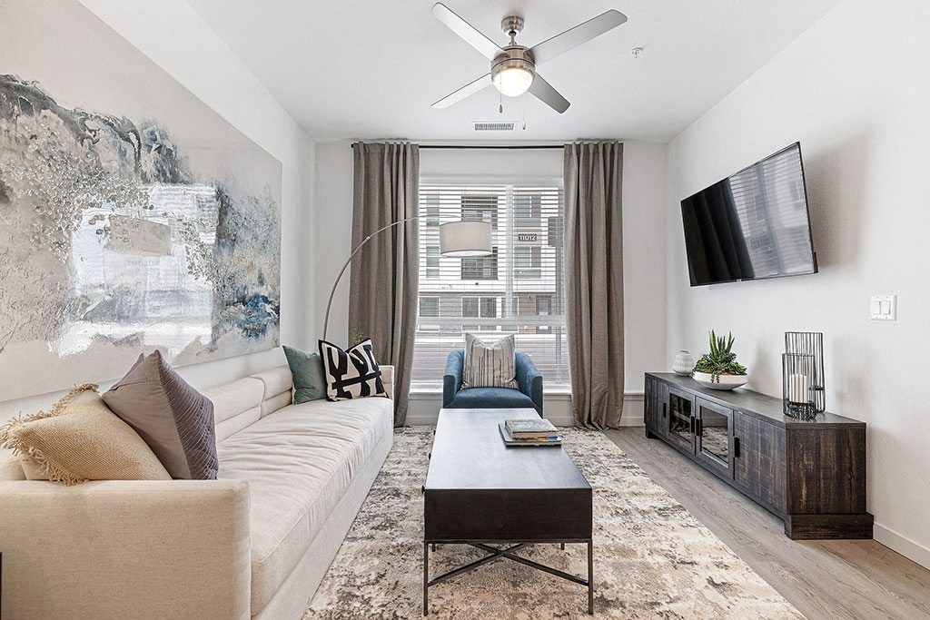 a living room with a ceiling fan and a large window