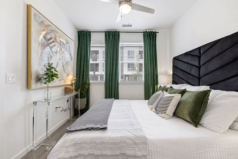 a bedroom with a large bed and green curtains