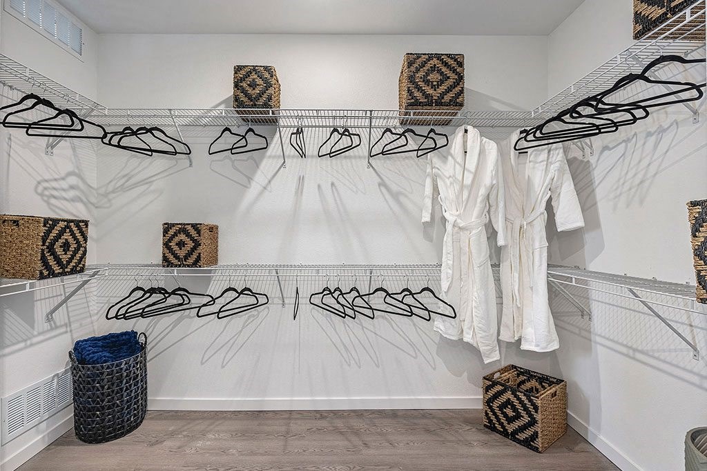 a walk in closet with a rack of shoes and bags