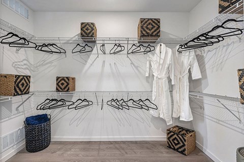 a walk in closet with a rack of shoes and bags