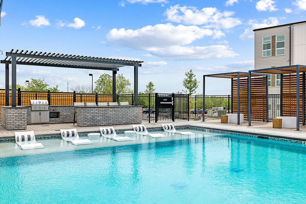 a swimming pool with lounge chairs next to a building