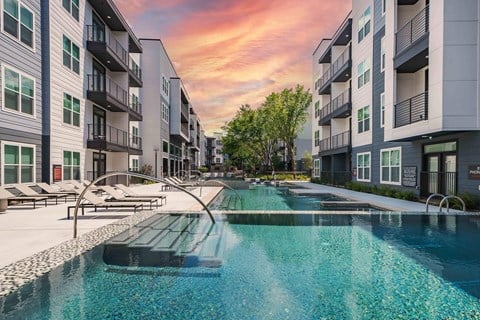 A swimming pool in front of apartment buildings.