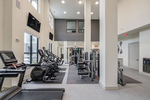 A gym with treadmills, weights, and exercise equipment.