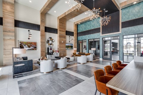 A modern lobby with a wooden floor and a large chandelier.