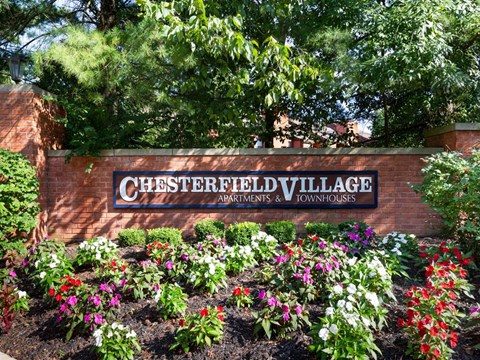 a sign in front of a flower garden