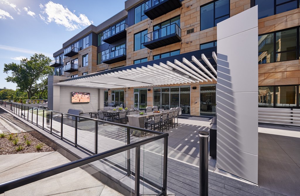 a patio with tables and chairs in front of a building