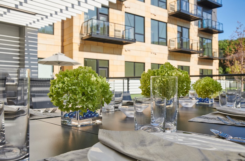 a table with glasses and plants on a patio