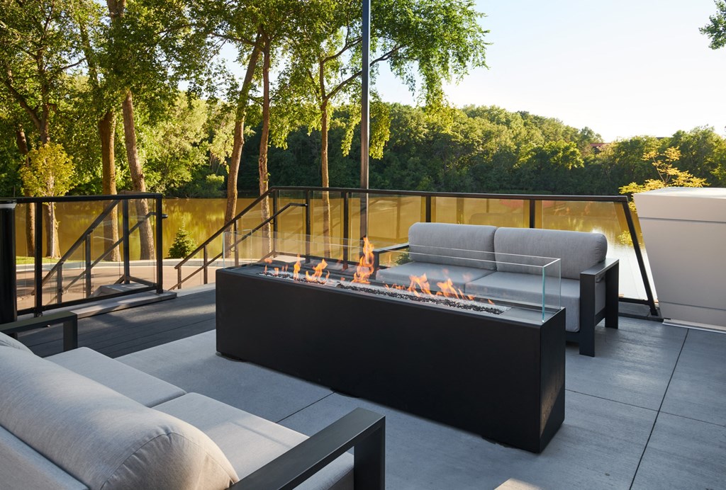 a patio with couches and a fire pit