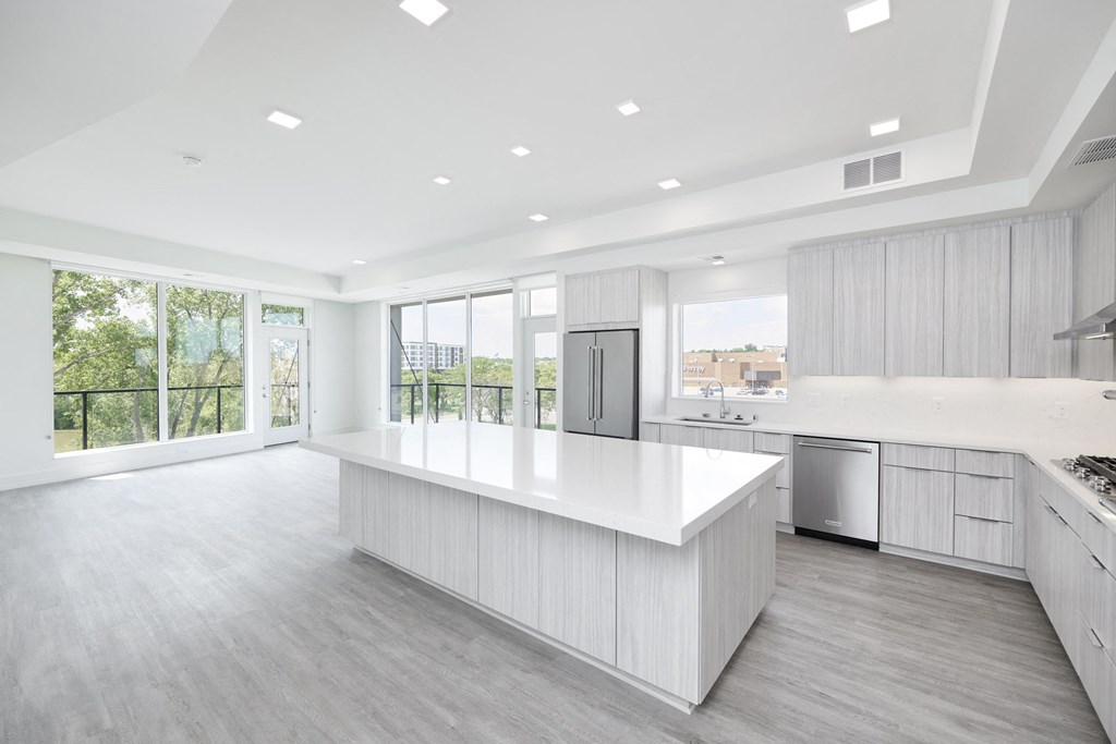 a large white kitchen with a large island in the middle