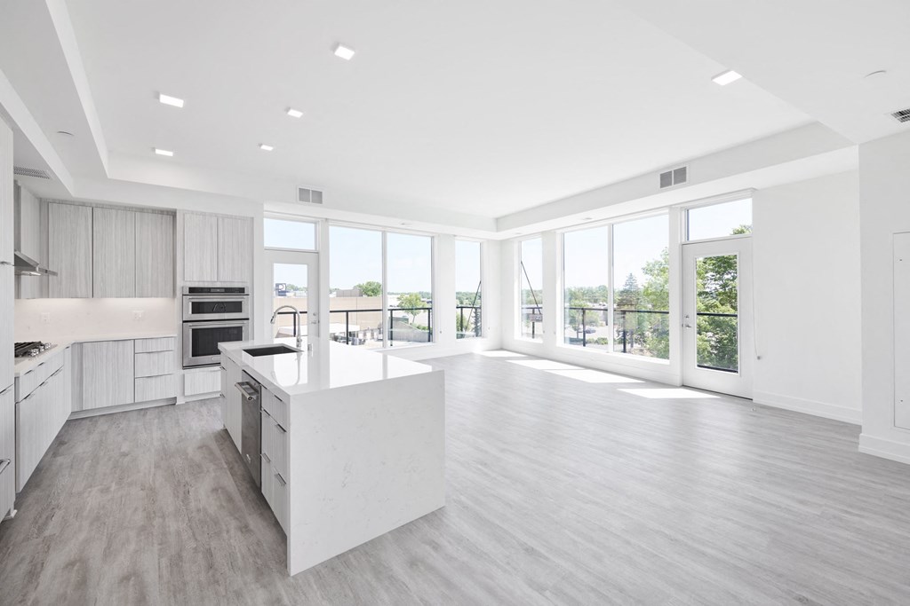 a large white kitchen with a large island in the middle