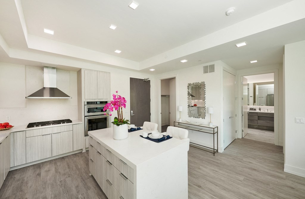 a large white kitchen with a white island and white cabinets