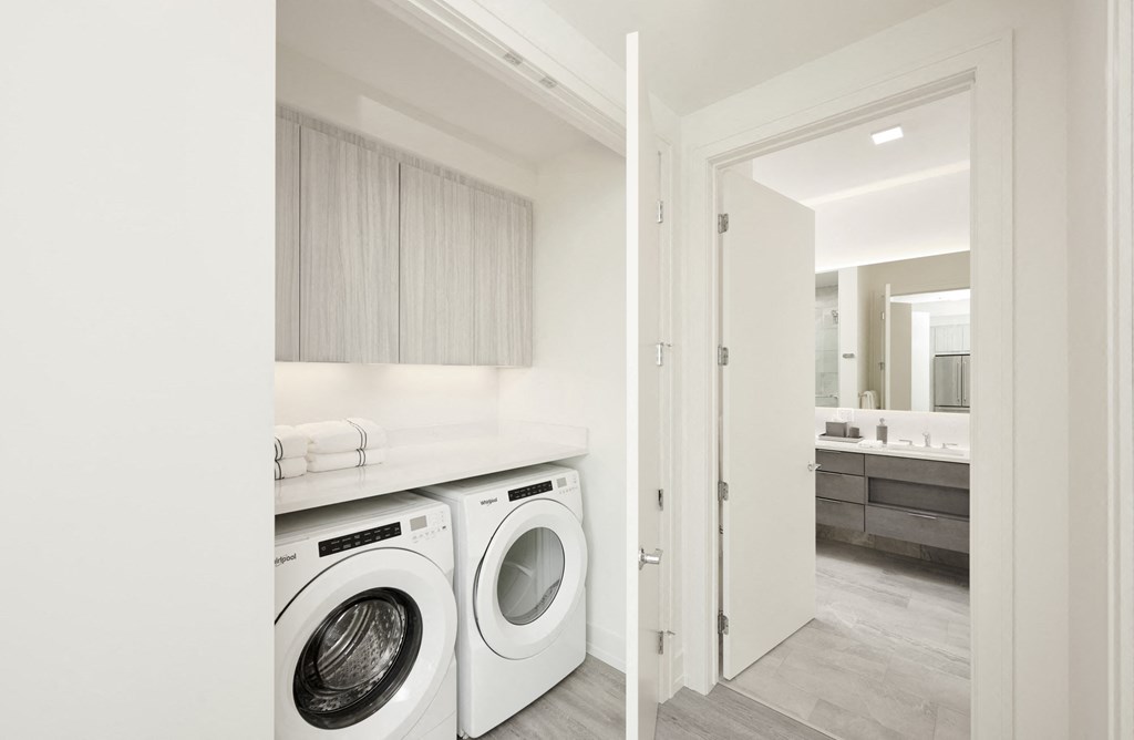 a white washer and dryer in a white laundry room