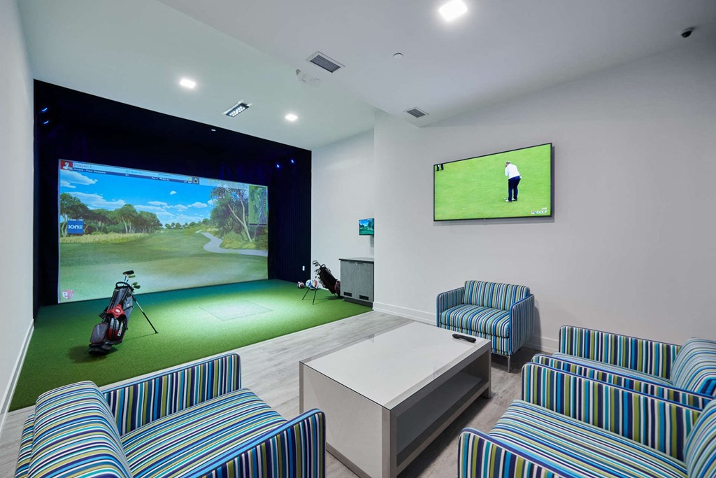 a games room with a golf simulator and a tv
