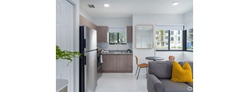 a kitchen and living room with a refrigerator and a sink