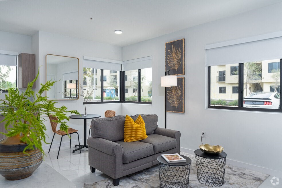 a living room with a couch and a table and windows