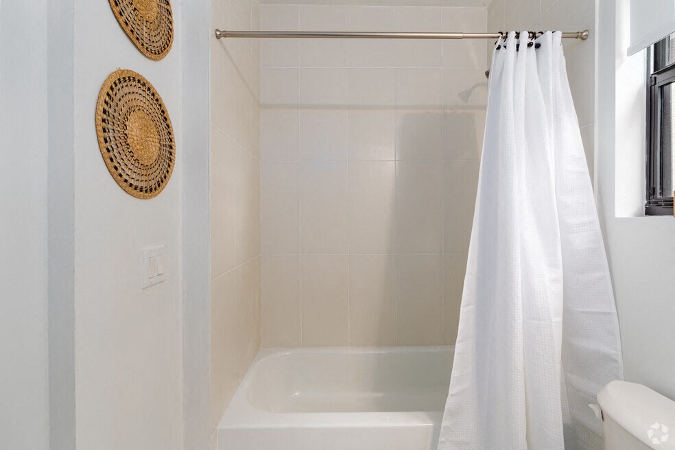 a white bathroom with a tub and a shower curtain