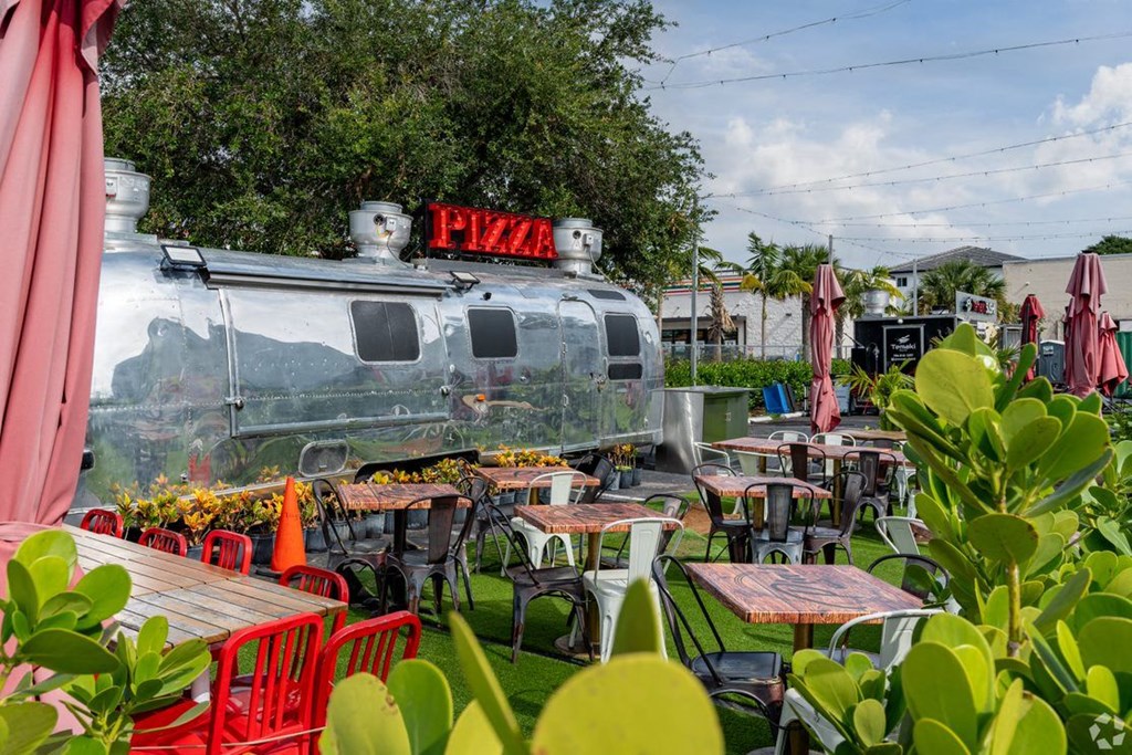 a train themed restaurant with tables and chairs and plants