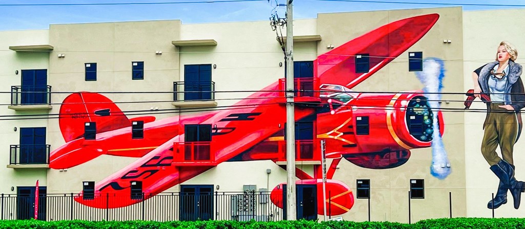 a mural of a red plane on the side of a building