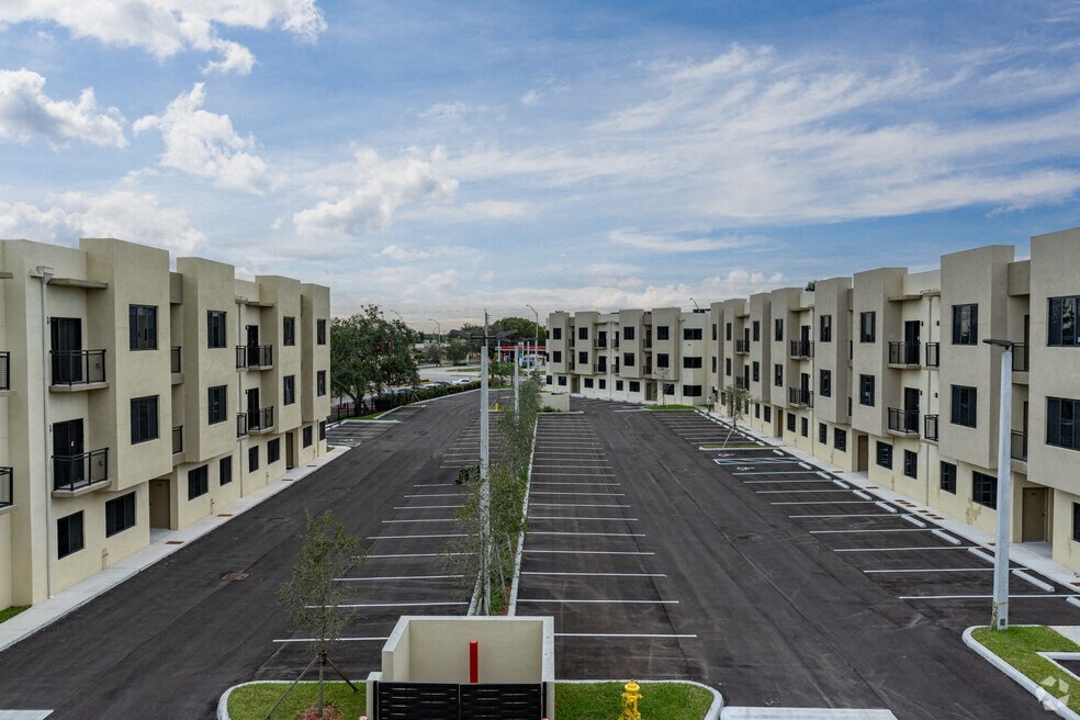 an empty parking lot between rows of apartment buildings