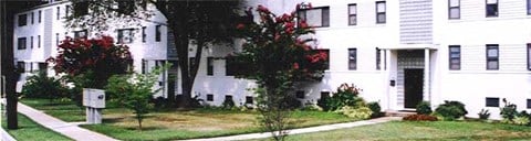 a large white house with a sidewalk in front of it