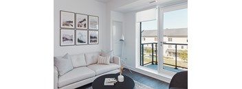 A living room with a white couch, a coffee table, and pictures on the wall.