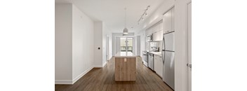 A modern kitchen with stainless steel appliances and wooden floors.