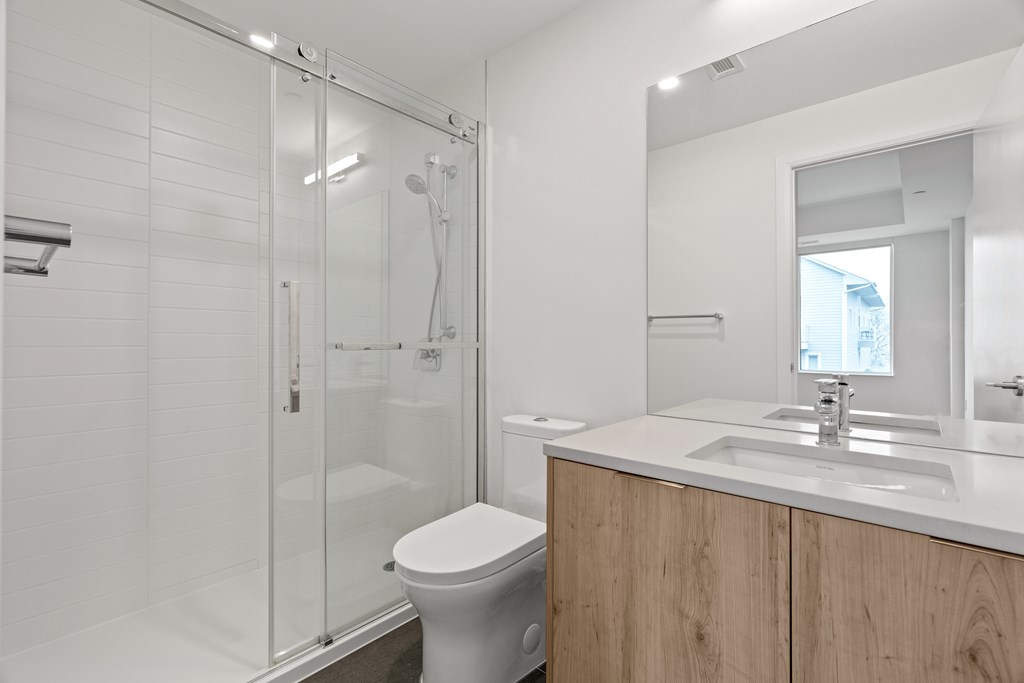 A white toilet sits next to a sink in a modern bathroom.
