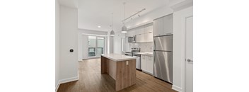 A modern kitchen with stainless steel appliances and wooden cabinets.