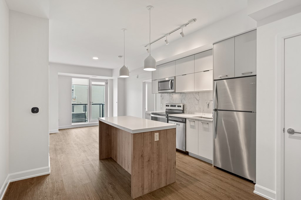 A modern kitchen with stainless steel appliances and wooden cabinets.
