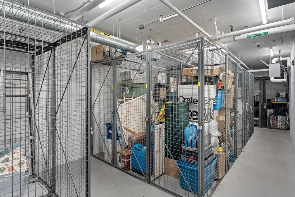 A storage room with wire mesh fencing and boxes on the shelves.