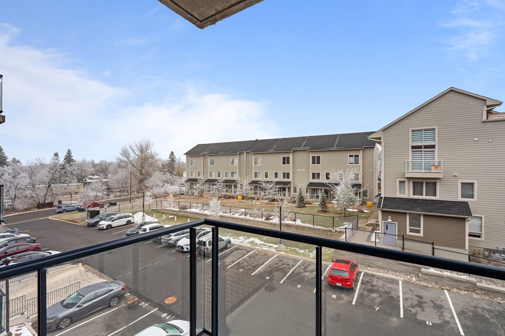 A parking lot with cars and a building in the background.