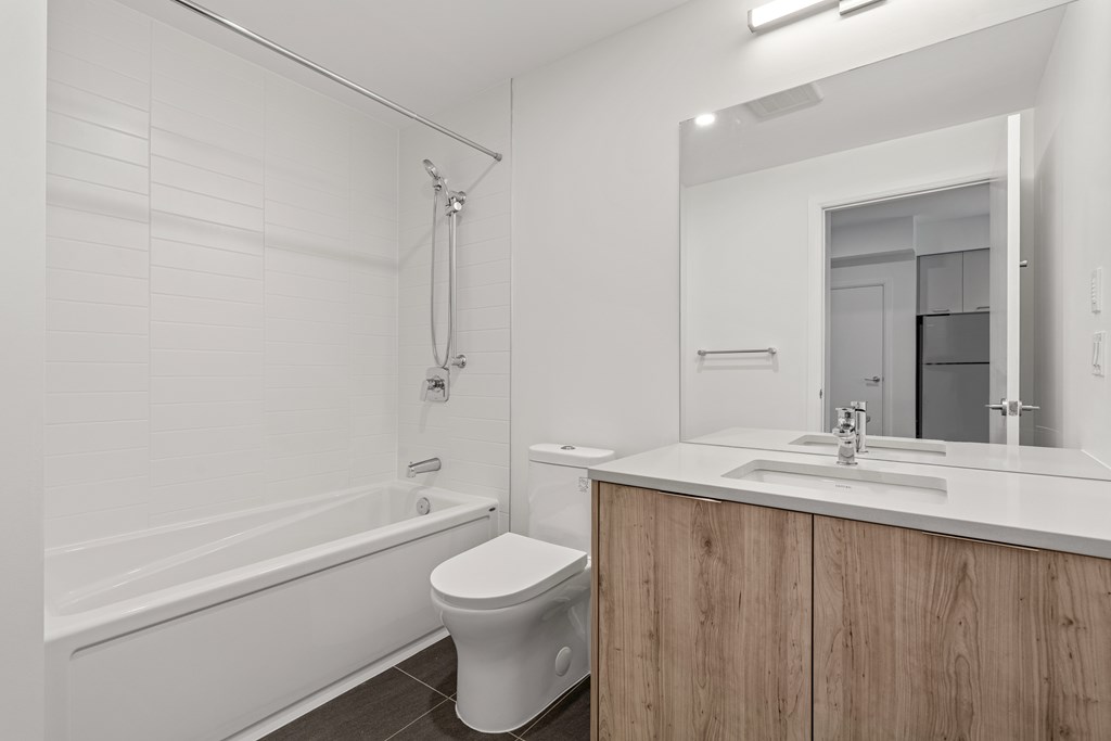 A white bathroom with a toilet, sink, and bathtub.