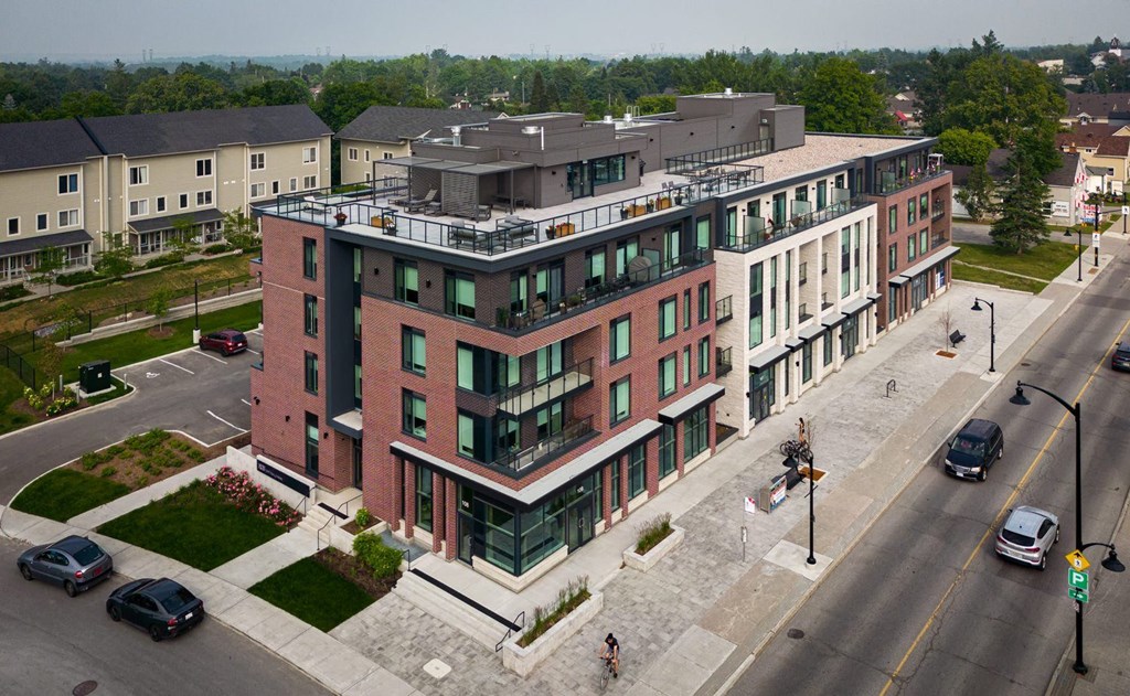 A modern red brick building with a balcony on the top floor.