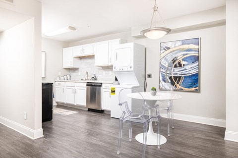 a kitchen with white cabinets and a white table and chairs