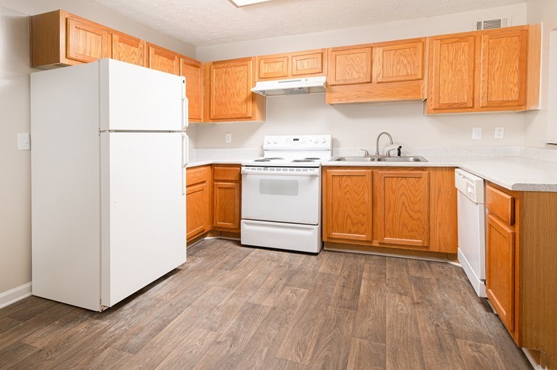 A kitchen with wooden cabinets and a white refrigerator.