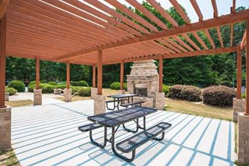 a patio with a picnic table and a fireplace