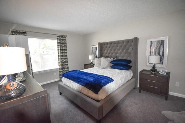 a bedroom with a bed and a dresser and a window