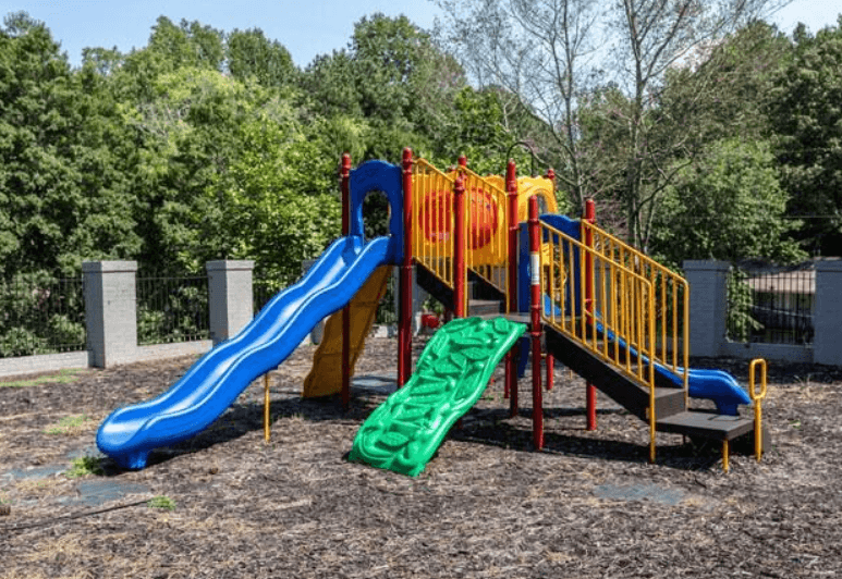 a playground with two slides and a green slide